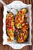 Aubergines filled with couscous, harissa, apricots, chickpeas and pomegranate seeds