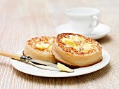 Crumpets with melting butter on a plate