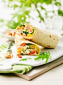 Cheese and salad wraps on a chopping board