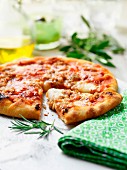 A sliced pizza with rosemary