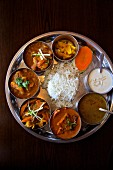 Thali with chicken, lamb, lentil soup, pickles, curried vegetable and rice (Nepal)