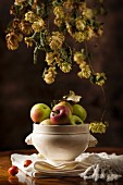 An autumnal arrangement featuring hops and apples