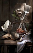 Old kitchen utensils in a wire basket and next to it on a wooden table