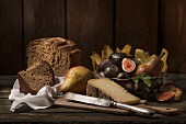 An autumnal arrangement featuring bread, cheese, pears and figs