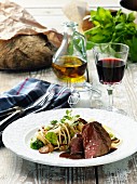 Beef fillet with pasta and a glass of red wine