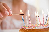 Small candles on a birthday cake being lit