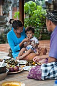 Asiatische Familie beim Essen auf Terrasse