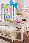 Festlich gedeckter Tisch und bunte Luftballons zum Kindergeburtstag