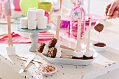 Marshmallows on sticks with chocolate glaze on a table at a birthday party