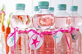 Bottles of water with self-printed labels and ribbons