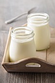 Two glasses of yoghurt on a wooden tray