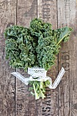Kale tied with a lace ribbon on a wooden surface