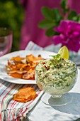 Mackerel and avocado cream with root vegetable crisps on a table outside