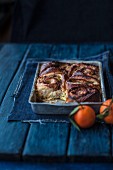 Apple and cinnamon buns in a baking try next to mandarins