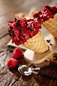 Raspberry ice cream with black olives in ice cream cones