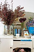 Dishes, books and flowers on old kitchen furniture