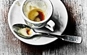 Espressotasse mit Resten von Kaffee und Löffel auf Untertasse