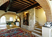 Mediterranes Wohnzimmer mit Steinwand und Balkendecke