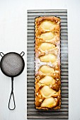 Pear and almond tart with icing sugar