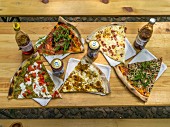 Various slices of pizza on a rustic wooden table
