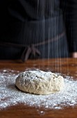 Bread dough being sprinkled with flour
