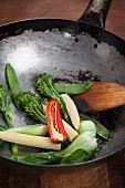 Oriental vegetables and a spatula in a wok