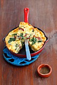 A pasta omelette with spinach and salami