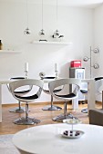 Glossy, white shell chairs in modern, white dining room