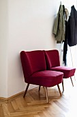 Rote Retro-Sessel im Flur neben einer Garderobe