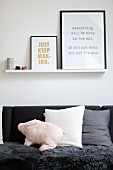 Framed prints on narrow shelf above sofa