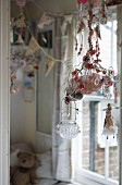 Windlichter an Drahtgestell aufgehängt mit Glasschmuck und Figuren dekoriert