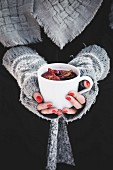 A woman holding a cup of mulled wine
