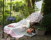 Comfortable seating area in garden with rose-patterned fabrics on lounger
