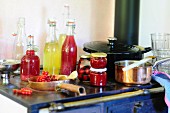 Various homemade fruit juices and preserved fruit on an old stove