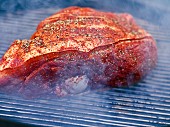 Spiced beef brisket being cooked in a smoker