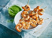 Grilled prawn skewers with green sauce
