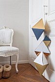 Geometric paper shapes hung from wardrobe door