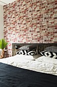Bed with rustic headboard against brick wall in bedroom