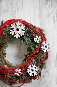 Wreath decorated with wooden snowflakes and red cord