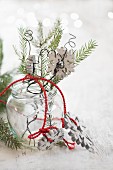 Wooden snowflake and sprig of fir in jam jar