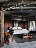 African style bedroom with straw walls and modern mosquito canopy