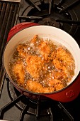 Chicken bits being fried in a pot