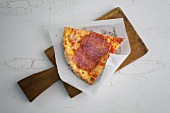 A slice of pizza with salami
