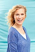 Junge blonde Frau in blau meliertem Langarmshirt