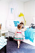 Children with wrapped presents in bedroom with white beds and elegant flair