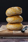 A stack of bagels on a wooden chopping board