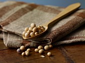 Soya beans on a wooden spoon on a jute cloth