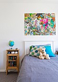 Boy's room with vintage bedside tables, illuminated globe and colorful comic poster over headboard