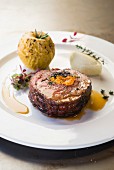 A pork collar steak filled with dried plums and blue cheese and served with a baked apple