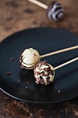 Cake pops with white and dark chocolate on a plate